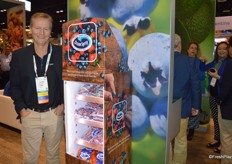 James Milne with Oppy stands next to a new product: an Ocean-Spray labeled cooler that can hold Ocean Spray berries as well as other Ocean-Spray labeled fruit. The refrigerator is small enough where it can be easily moved to different parts of the store to increase cross merchandising. The refrigerator is being tested in a select number of stores in the Denver area. 